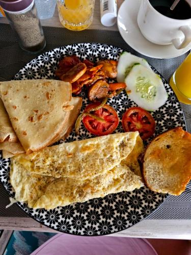 a plate of food with bread and tomatoes on a table at White Star Ocean View Hotel in Paje