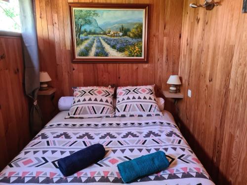 une chambre avec un lit et un tableau au mur dans l'établissement Chalet à Brazey-en-Morvan, à Brazey-en-Morvan