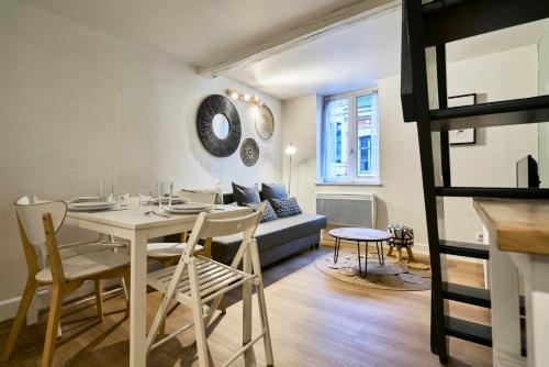een woonkamer met een tafel en een bank bij Triplex in the heart of Old Lille in Lille