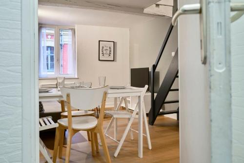 een eetkamer met een witte tafel en stoelen bij Triplex in the heart of Old Lille in Lille