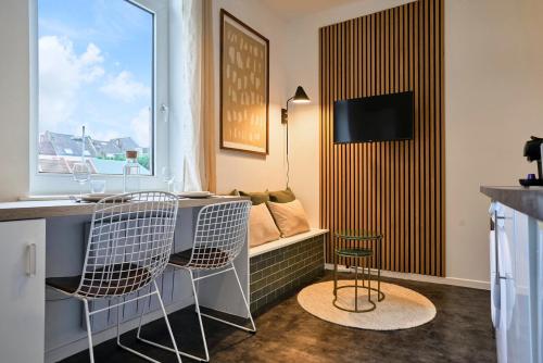 een kamer met 2 stoelen en een bureau met een raam bij 1 bedroom apartment near Villa Cavrois - Croix in Croix