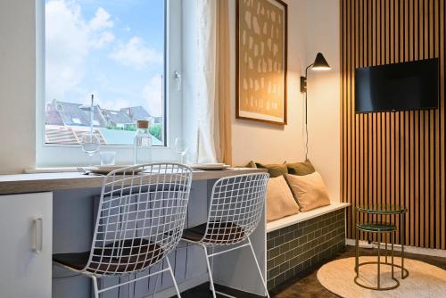 une cuisine avec un bar avec deux chaises et une fenêtre dans l'établissement 1 bedroom apartment near Villa Cavrois - Croix, à Croix