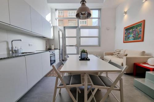 uma cozinha e sala de estar com mesa e cadeiras em Loft Filipinas Vibes Coruña em La Coruña