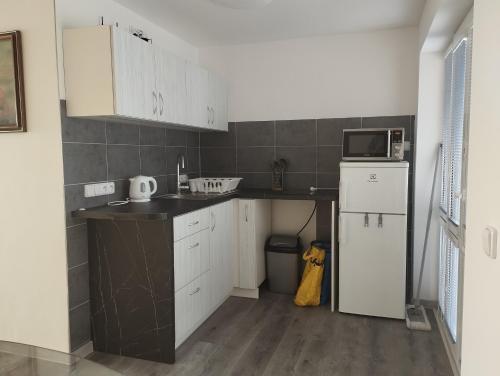 a kitchen with white cabinets and a white refrigerator at Apartmán na Vyhlídce in Šumperk