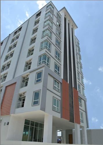 a tall white building with a lot of windows at Good Morning Apartment in Ban Bang Khan