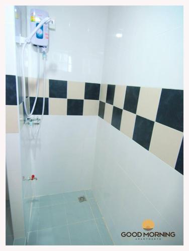 uma casa de banho com um chuveiro e uma porta de vidro em Good Morning Apartment em Ban Bang Khan