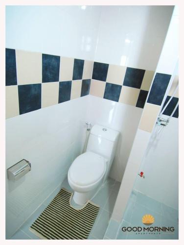 uma casa de banho com um WC e uma cabina de duche em vidro. em Good Morning Apartment em Ban Bang Khan