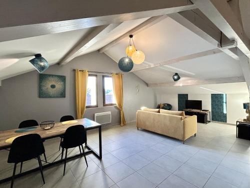ein Wohnzimmer mit einem Sofa, einem Tisch und Stühlen in der Unterkunft M48 *Marquer* T2 atypique Cranves-Sales in Cranves-Sales