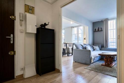 un salon avec un canapé et un chat assis sur un meuble dans l'établissement Vieux-Lille equipped apartment with parking, à Lille