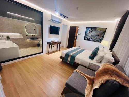 a bedroom with a bed and a bathroom with a tub at Box A.venu in Calapan