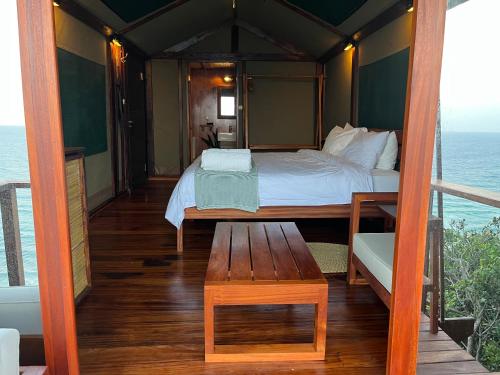 a bedroom with a bed and a table on a balcony at Sky Island Resort in Ponta Malongane
