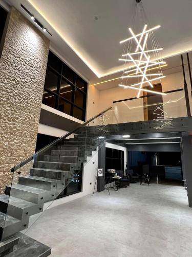 a lobby with a staircase and a chandelier at Box A.venu in Calapan