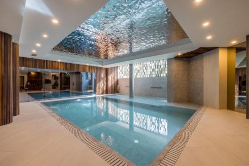 a swimming pool in a house with a glass ceiling at Hotel Fanat in Split