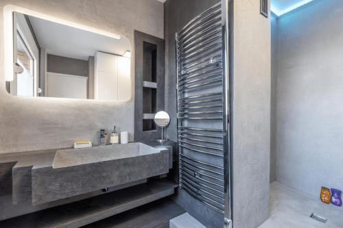een badkamer met een wastafel en een spiegel bij Hypercentre: apartment near station with parking in Lille