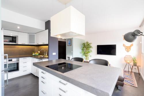 une cuisine avec des placards blancs et un grand îlot dans l'établissement Hypercentre: apartment near station with parking, à Lille