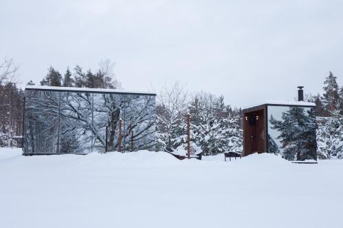 a glass building in the snow with trees at ÖÖD Hötels Roosisaare – with sauna in Roosisaare