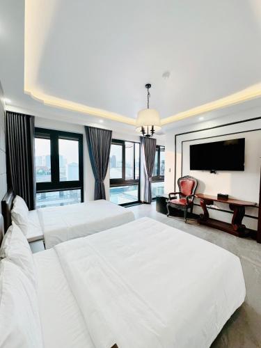 a bedroom with two beds and a flat screen tv at SALA HOTEL HUE in Hue