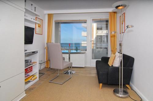 ein Wohnzimmer mit einem Sofa und einem Stuhl in der Unterkunft Haus am Meer, Whg 110, Seeseite in Westerland