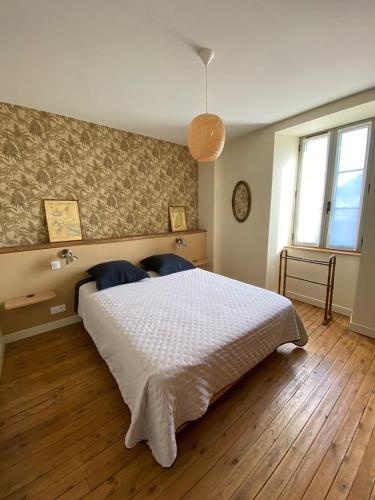 a bedroom with a large white bed in a room at Maison Denise - Au coeur du Périgord Noir in Castelnaud La Chapelle
