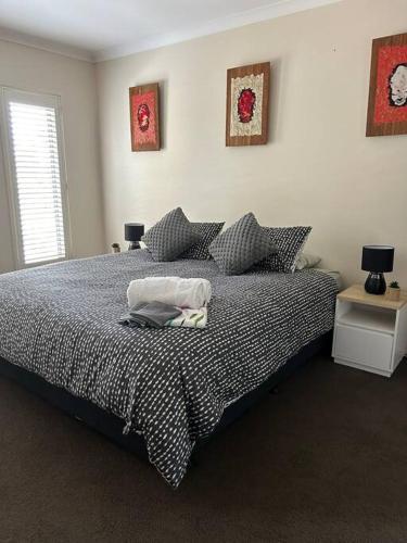 a bedroom with a bed and two tables with lamps at Portarlington Family Fun House in Portarlington