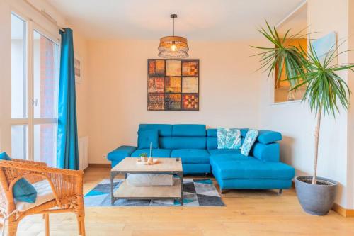 un salon avec un canapé bleu et une table dans l'établissement 2 BR apartment with balconies & private parking, à La Madeleine