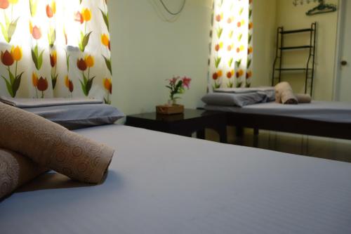 盧納將軍城的住宿－Mi Casa Suites Siargao，窗帘上有鲜花的房间里设有两张床