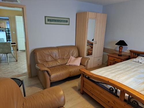 ein Schlafzimmer mit einem Bett, einem Sofa und einem Stuhl in der Unterkunft Ferienhaus Wilhelm Spreewald in Straupitz