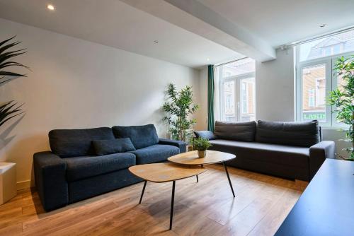 un salon avec un canapé bleu et une table dans l'établissement Lille Centre - Superbe appart. avec terrasse !, à Lille