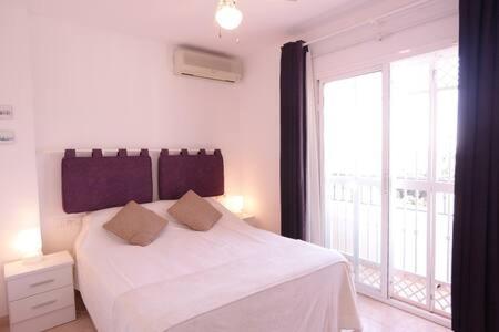 En eller flere senge i et værelse på Amplio apartamento con piscina cerca de la playa