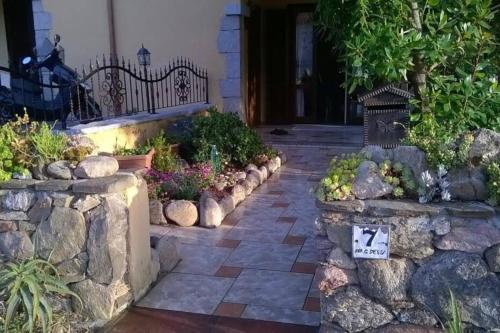 a garden with a stone wall and some plants at AffittaSardegna-Casa Dora in Agrustos