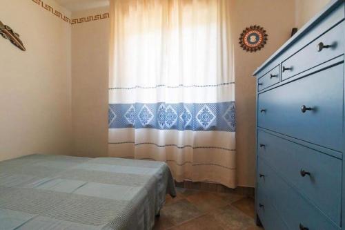 a bedroom with a bed and a window with a curtain at AffittaSardegna-Casa Dora in Agrustos