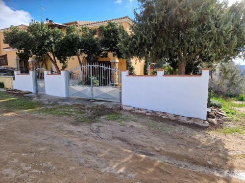 a white fence in front of a house at AffittaSardegna-Casa Dora in Agrustos