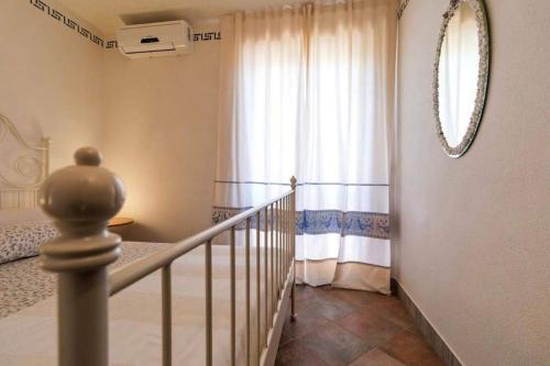 a room with a staircase with a window and a mirror at AffittaSardegna-Casa Dora in Agrustos