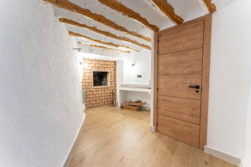 a room with a wooden door and a brick wall at Casa Rural Hoyo del moro in Liétor