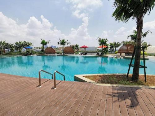 a large swimming pool with a palm tree next to it at Almas Suites Netflix Wifi Puteri Harbour By STAY in Nusajaya