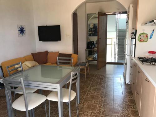 a kitchen and a living room with a table and chairs at Frontemare in Crotone