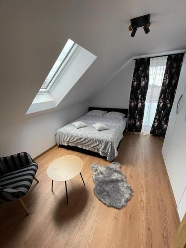 a bedroom with a bed and a table and a window at Apartament Szary 14/2 in Starogard Gdański