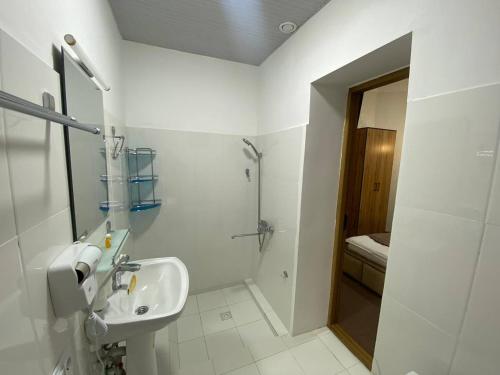 a white bathroom with a sink and a shower at HOTEL KARVON SHAHRISABZ in Shahrisabz