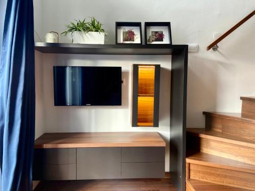a living room with a tv on a wall at Olimian Retreat Rosa 421 in Podčetrtek