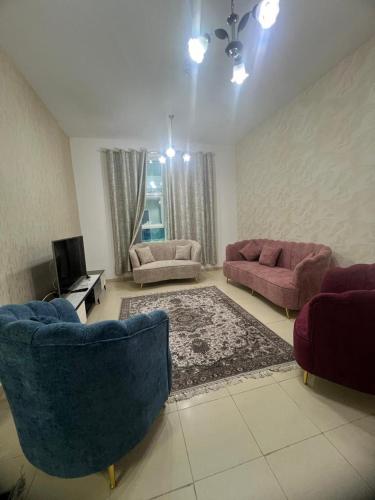 ein Wohnzimmer mit 2 Sofas und einem TV in der Unterkunft furnished apart in city tower in Ajman 