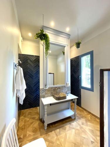 une salle de bain avec un lavabo et un miroir dans l'établissement Le Pavillon d'été 4* - élégant et lumineux, à Saint Alban Auriolles