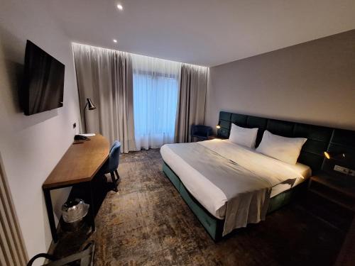 a hotel room with a bed and a desk at iNova in Zagreb