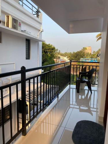 a balcony with a black railing and a chair at Kandamangalath Affinity in Ernakulam