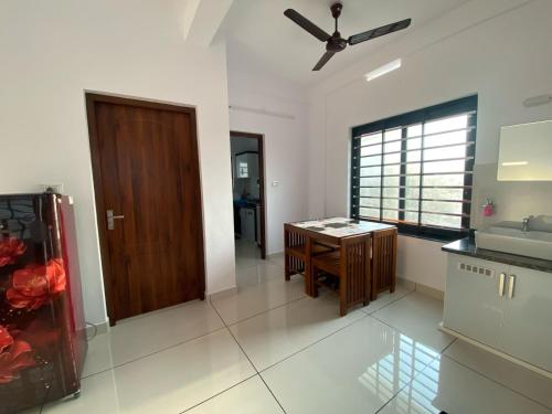 a kitchen with a sink and a wooden door at Kandamangalath Affinity in Ernakulam