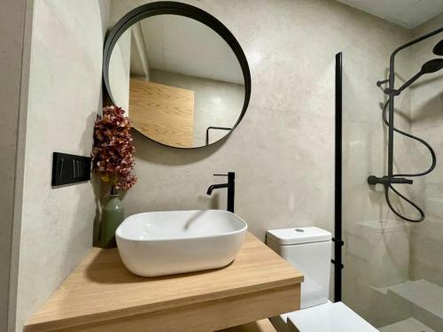 een badkamer met een witte wastafel en een spiegel bij Suite El Geranio in Córdoba
