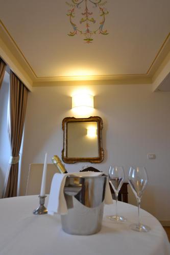a table with two wine glasses and a mirror at Palazzo Riccucci in Montappone