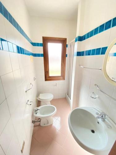 a white bathroom with a sink and a toilet at Cinta 1 in San Teodoro