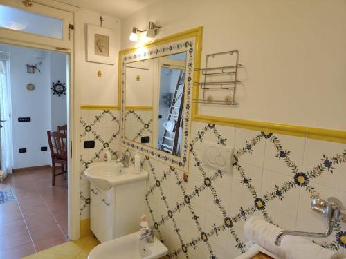 a bathroom with a sink and a toilet and a mirror at Piccola Perla in Amalfi