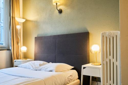 une chambre avec un lit avec deux tables et deux lampes dans l'établissement Lille Centre - Large functional studio, à Lille