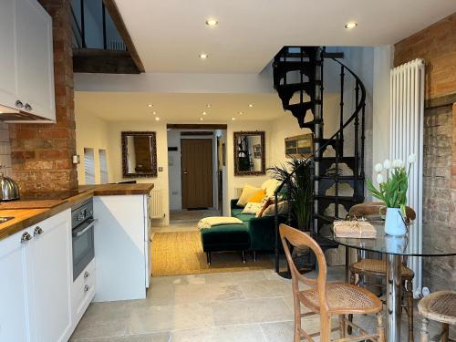 a kitchen and living room with a table and chairs at The Forge in Towcester